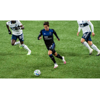 The San Jose Earthquakes' lone goal-scorer of the match, Carlos Fierro, dribbles near a pair of Whitecaps FC defenders